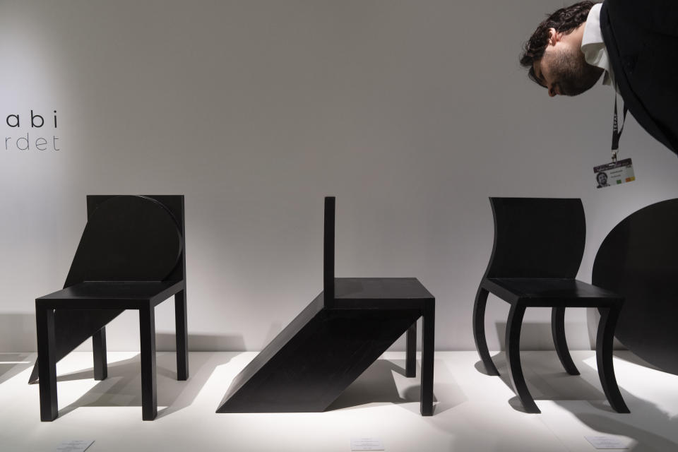 A person looks at contemporary chairs by Paolo Pallucco at the European Fine Art Foundation, known by its acronym TEFAF, in Maastricht, southern Netherlands, Thursday, March 7, 2024. (AP Photo/Peter Dejong)