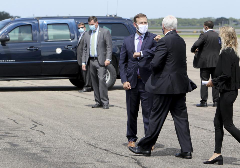 Florida Representative Chris Sprowls, center, offers an elbow bump to Vice President Mike Pence after he arrived in Tampa on Air Force Two with his daughter Charlotte, right, at Tampa International Airport on Wednesday Aug. 5, 2020, with plans to visit the Hilton Clearwater Beach Resort & Spa in Clearwater as part of his 'Faith in America' tour. (Douglas R. Clifford/Tampa Bay Times via AP)