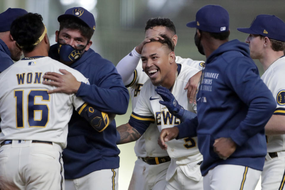 Milwaukee Brewers' Orlando Arcia celebrates with teammates after driving in the winning run during the 10th inning of the team's opening-day baseball game against the Minnesota Twins on Thursday, April 1, 2021, in Milwaukee. (AP Photo/Aaron Gash)