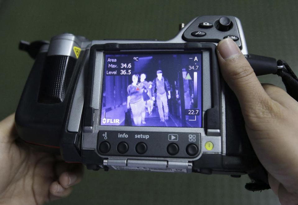 FILE- In this Wednesday, April 16, 2014 photo, Passengers are seen on a thermal scanner as they arrive at Manila's International Airport in Paranaque, south of Manila, Philippines. One expert says recent outbreaks of MERS in Saudi Arabia and the United Arab Emirates that led to more than 20 infections, many among health-care workers, “have put us into uncharted territory.” (AP Photo/Aaron Favila, File)