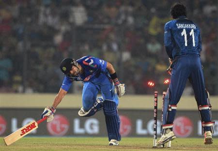 Virat Kohli runs to avoid a run out as Sri Lanka's wicketkeeper Kumar Sangakkara (R) breaks the wicket to dismiss him successfully, during their ICC Twenty20 World Cup cricket final match at the Sher-E-Bangla National Cricket Stadium in Dhaka April 6, 2014. REUTERS/Stringer