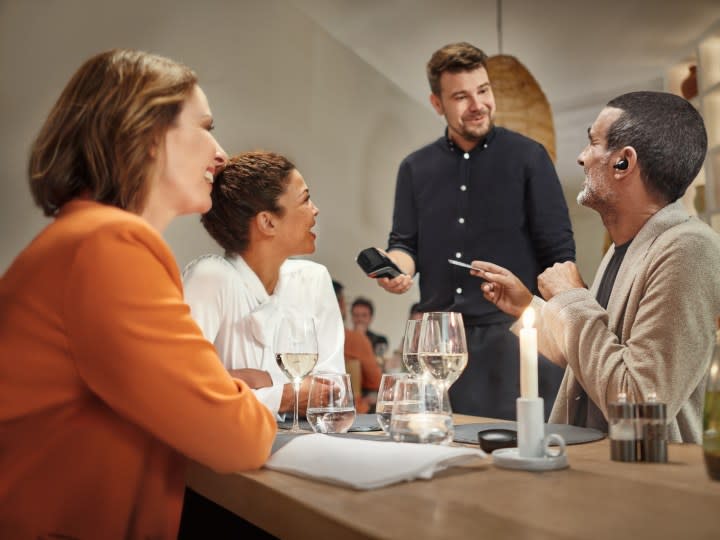 Sennheiser Conversation Clear Plus being worn at restaurant to hear