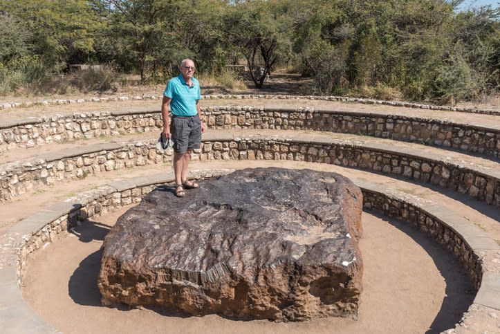 A man standing on the large meteorite