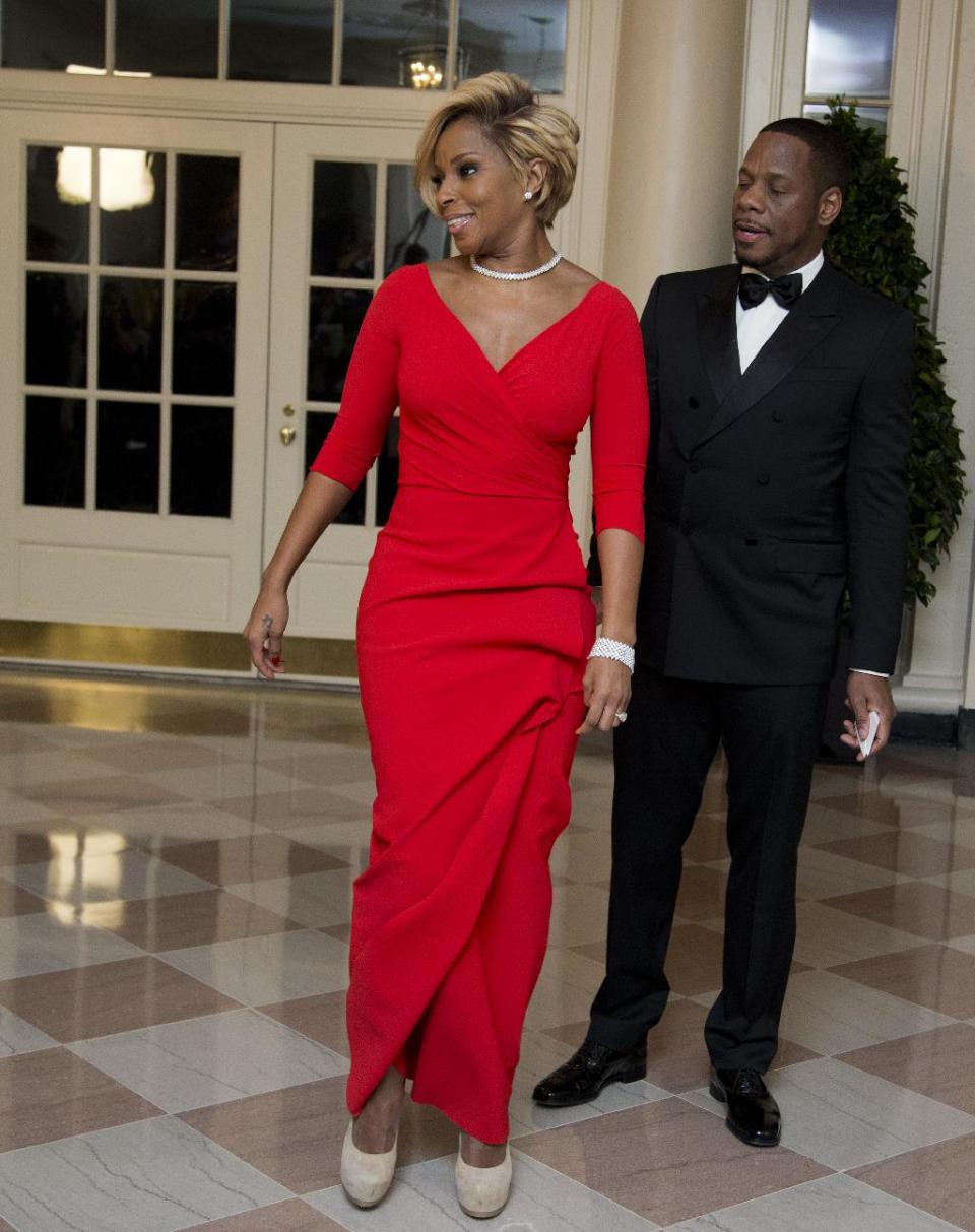 Singer Mary J. Blige, and Kendu Isaacs, left, arrive for a State Dinner in honor of French President François Hollande, at the White House in Washington, Tuesday, Feb. 11, 2014. (AP Photo/Manuel Balce Ceneta)