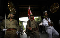 FILE- In this Sunday, Aug. 15, 2010 file photo, visitors in Japanese Imperial army and navy uniforms enter Yasukuni Shrine, which honors Japan's war dead, including convicted war criminals, during a ceremony marking the 65th anniversary of the end of World War II, in Tokyo. The Tokyo shrine and the memorial hall in Nanjing, as Nanking is now called, are physical embodiments of divergent views of history that still strain China-Japan relations, 70 years after the war. (AP Photo/Junji Kurokawa, File)