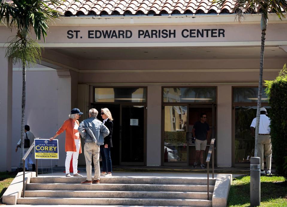 Volunteers, voters and poll workers chat outside St. Edward Parish Center Tuesday.