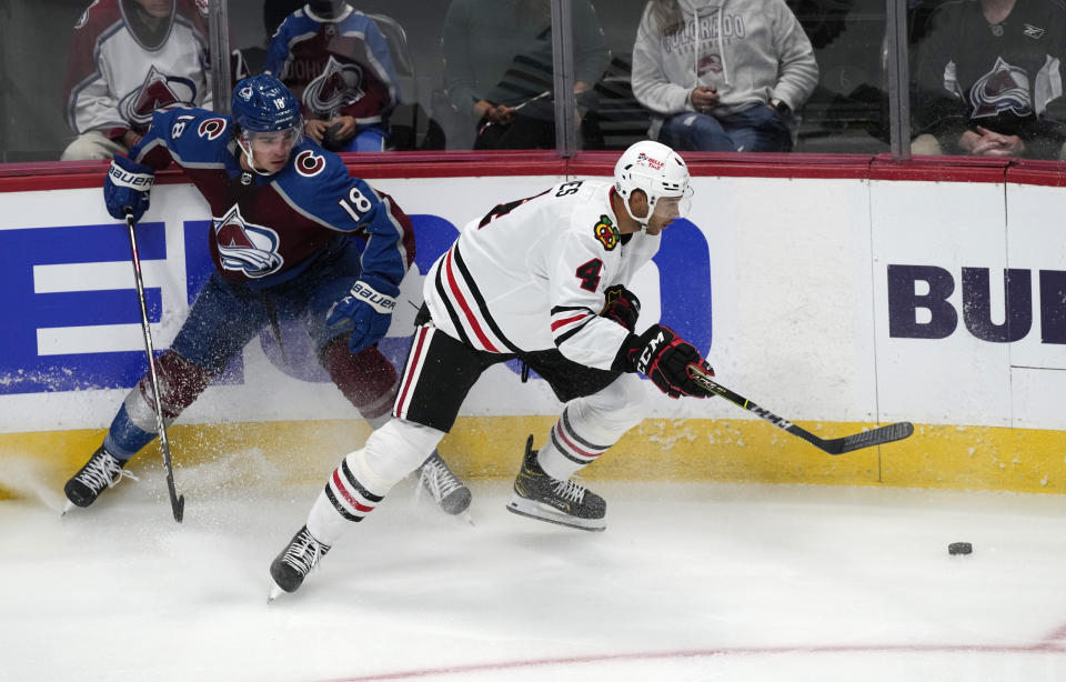 Chicago Blackhawks defenseman Seth Jones, right, fights for control of the puck with Colorado Avalanche center Alex Newhook in the first period of an NHL hockey game Wednesday, Oct. 13, 2021, in Denver. (AP Photo/David Zalubowski)