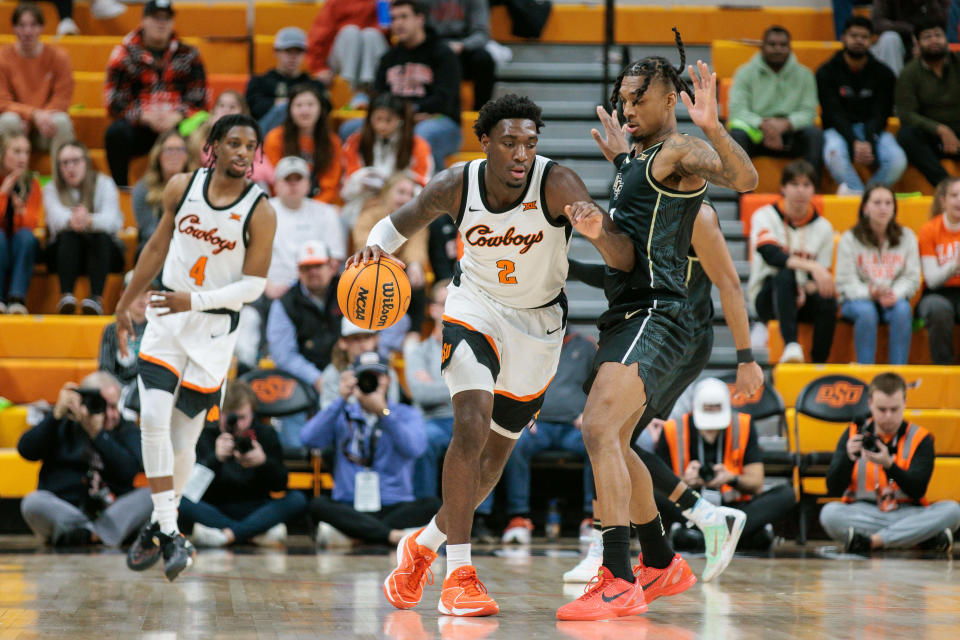 Feb 28, 2024; Stillwater, Oklahoma, USA; Oklahoma State Cowboys forward Eric Dailey Jr. (2) drives around UCF Knights guard Antwann Jones (1) during the first half at Gallagher-Iba Arena. Mandatory Credit: William Purnell-USA TODAY Sports