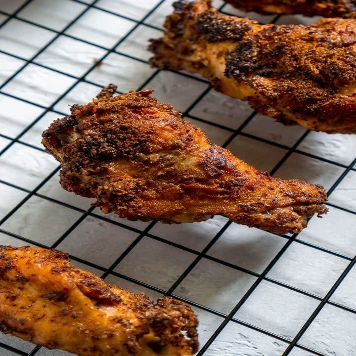 Chicken wings cooling on a wire rack.