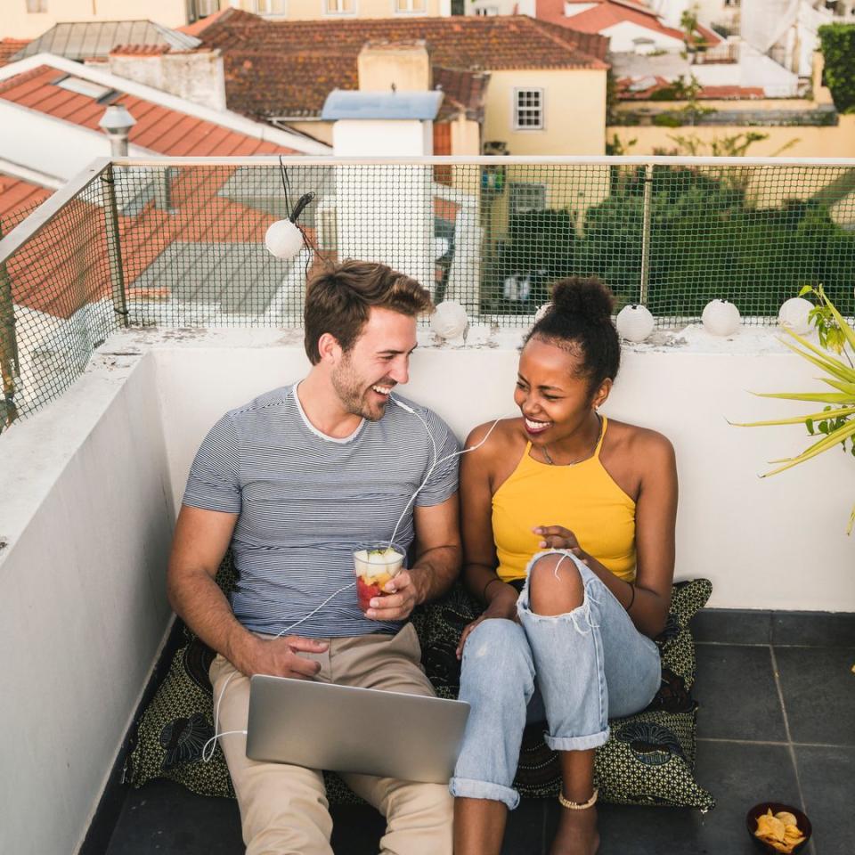 Pareja sentada en una terraza de Lisboa con un ordenador