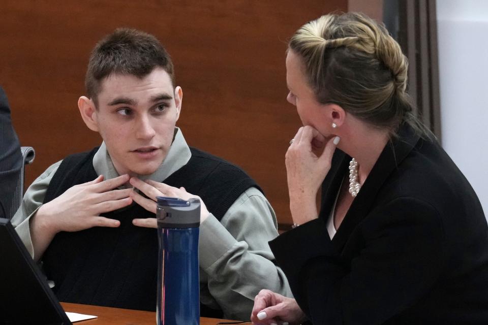 Marjory Stoneman Douglas High School shooter Nikolas Cruz fixes his collar as he speaks with Assistant Public Defender Melisa McNeill during jury selection in the penalty phase of his trial at the Broward County Courthouse in Fort Lauderdale on Tuesday, June 28, 2022 (© South Florida Sun Sentinel 2022)