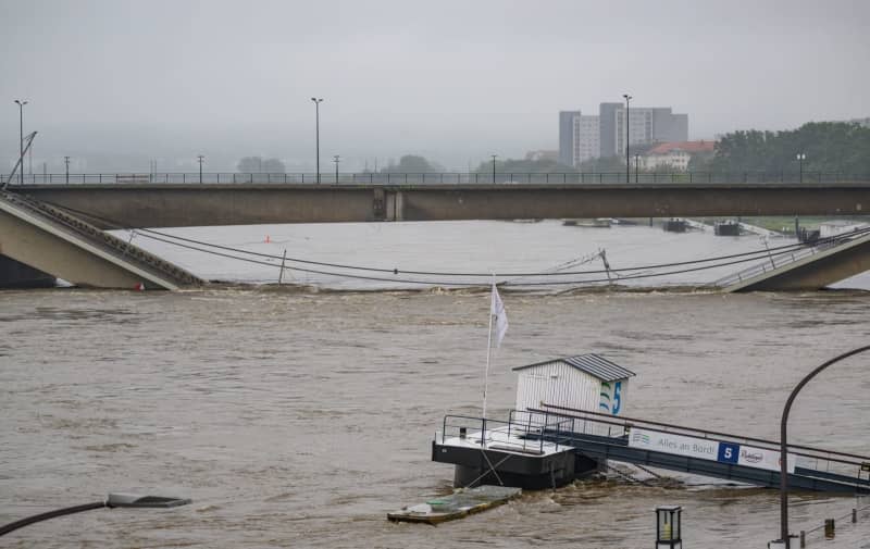 The flooded Elbe flows along the partially collapsed Carola Bridge. Robert Michael/dpa