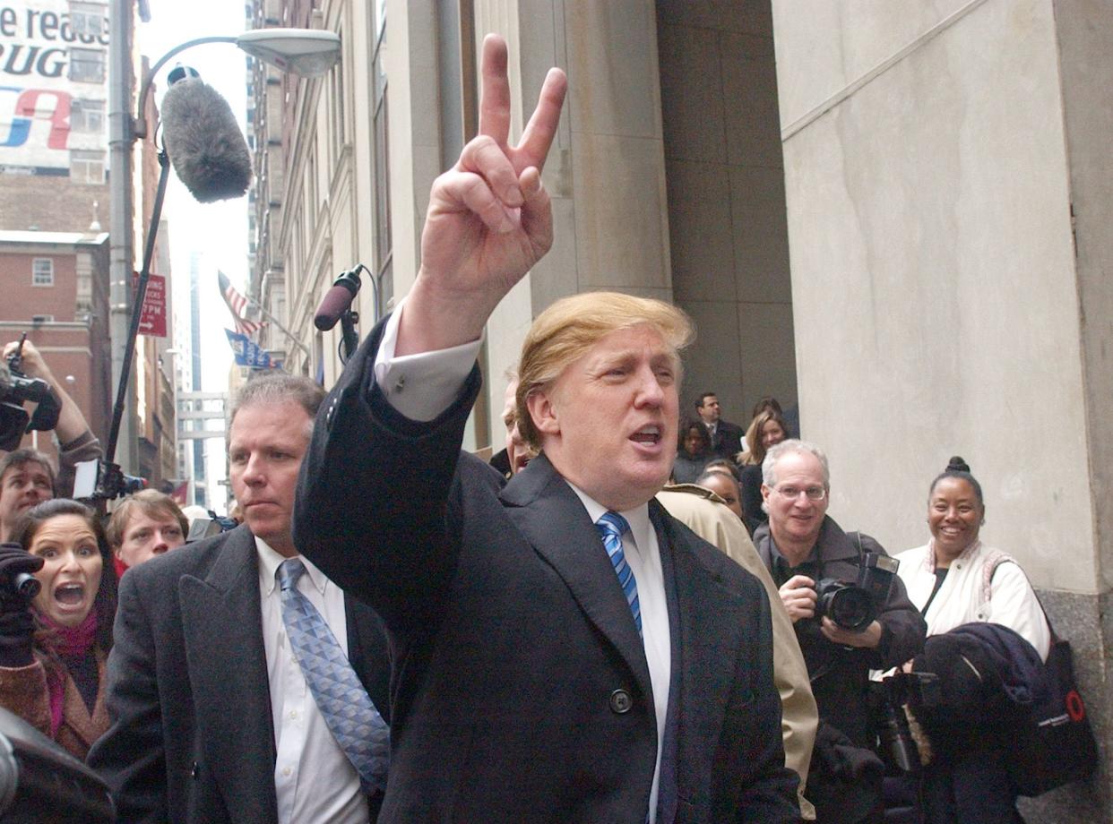 Developer Donald Trump, center, signals to those waiting in line at a casting call for the second season of his televisIon show, "The Apprentice," on March, 18, 2004 in New York.