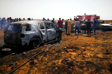 People gather at the site where a car bomb hit a funeral of a former senior military commander at Huwari cemetery in Benghazi