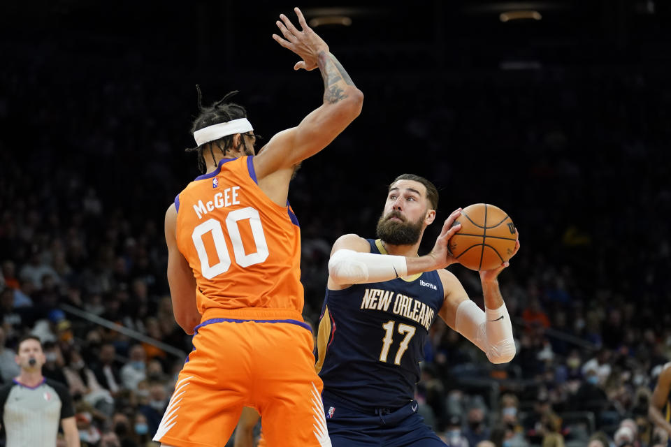 New Orleans Pelicans center Jonas Valanciunas (17) shoots as Phoenix Suns center JaVale McGee (00) defends during the first half of an NBA basketball game, Friday, Feb. 25, 2022, in Phoenix. (AP Photo/Matt York)