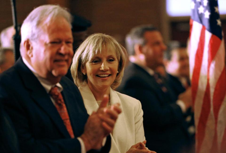 New Jersey Lt. Gov. Kim Guadagno with her husband Michael during a prayer service in celebration of her inauguration with Gov. Chris Christie at the New Hope Baptist Church on Tuesday, Jan. 21, 2014 in Newark. The celebrations to mark the start of Christie's second term could be tempered by investigations into traffic tie-ups that appear to have been ordered by his staff for political retribution and an allegation that his administration linked Superstorm Sandy aid to approval for a real estate project. (AP Photo/Rich Schultz)