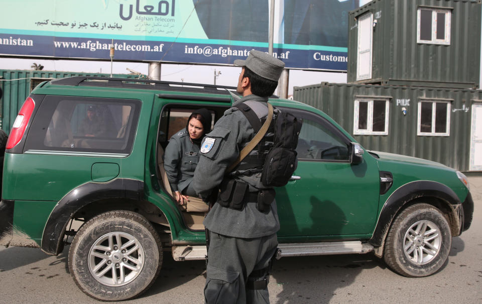 Afghanistan's first-ever female district police chief, Col. Jamila Bayaz, 50, left, gets off a police vehicle to review a check post in Kabul, Afghanistan, Thursday, Jan. 16, 2014. Afghanistan's first-ever female district police chief drew stares on Thursday as she drove and walked around the center of the city, reviewing check points and some of the important business and administrative facilities she is tasked with protecting. (AP Photo/Massoud Hossaini)
