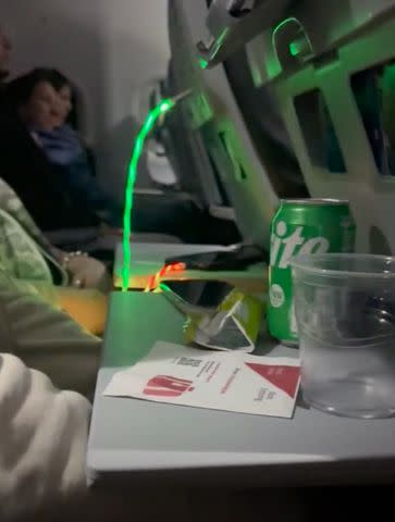 <p>Sam Psihoyos/ Bon Voyaged/ TMX</p> Passenger using neon flashing charger on plane