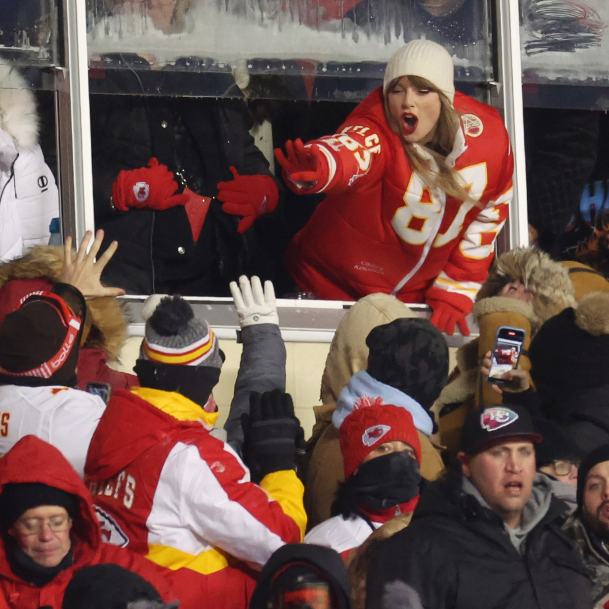  Taylor Swift celebrates with fans during the AFC Wild Card Playoffs between the Miami Dolphins and the Kansas City Chiefs at GEHA Field at Arrowhead Stadium on January 13, 2024 in Kansas City, Missouri. . 