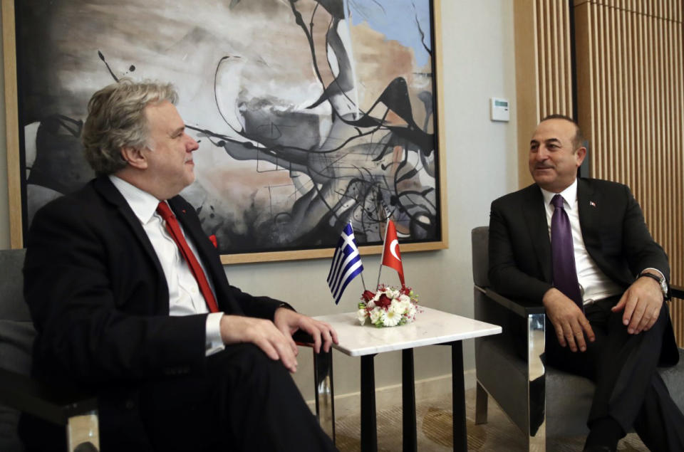 Turkey's Foreign Minister Mevlut Cavusoglu, right, and his Greek counterpart Giorgos Katrougalos speak in the Mediterranean coastal city of Antalya, Turkey, Thursday, March 21, 2019. Cavusogly says the defense chiefs of Turkey and Greece could meet soon as part of new confidence-building measures aimed at reducing tensions between the NATO allies. (Turkish Foreign Ministry via AP, Pool)