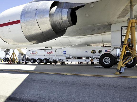 This image shows technicians and engineers at Vandenberg Air Force Base in California connecting the Pegasus XL rocket with the Interface Region Imaging Spectrograph, or IRIS, solar observatory to the Orbital Sciences L-1011 carrier aircraft.