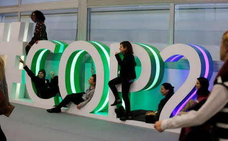 People pose for a picture inside the venue of the COP24 U.N. Climate Change Conference 2018 in Katowice, Poland December 11, 2018. Agencja Gazeta/Grzegorz Celejewski via REUTERS