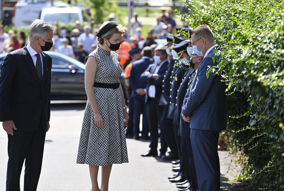 Belgium's King Philippe, left, and Belgium's Queen Mathilde, second left, speak with emergency workers prior to one minute of silence to pay respect to victims of the recent floods in Belgium, in Verviers, Belgium, Tuesday, July 20, 2021. Belgium is holding a day of mourning on Tuesday to show respect to the victims of the devastating flooding last week, when massive rains turned streets in eastern Europe into deadly torrents of water, mud and flotsam. (Eric Lalmand, Pool Photo via AP)