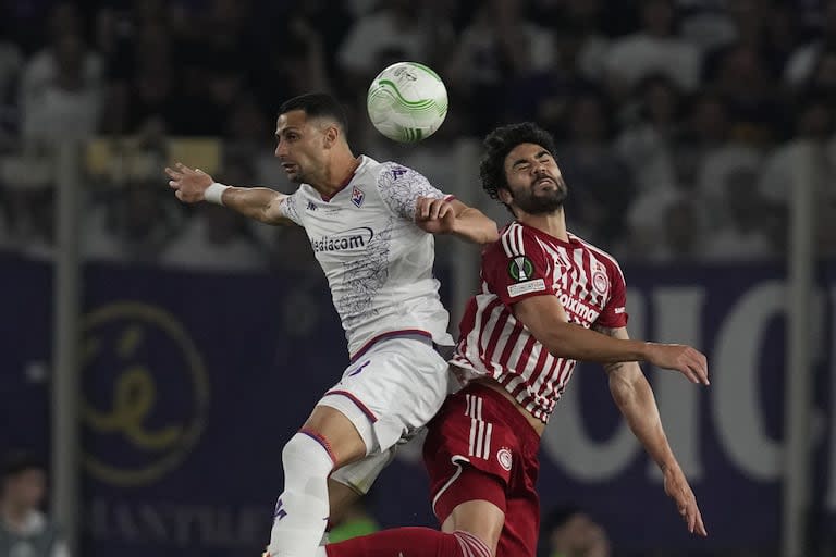 Fiorentina's Rolando Mandragora, left, heads the ball past Olympiacos' Vicente Iborra during the Conference League final soccer match between Olympiacos FC and ACF Fiorentina at OPAP Arena in Athens, Greece, Wednesday, May 29, 2024. (AP Photo/Thanassis Stavrakis)