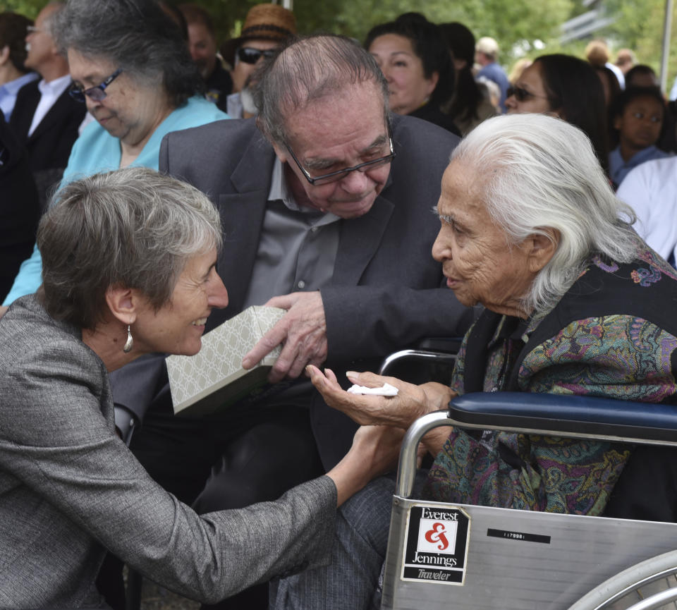 FILE - In this July 19, 2016 file photo Hank Adams, center, looks on as U.S. Interior Secretary Sally Jewell, left, greets 92 year-old Maiselle Bridges, right, during the celebration of the renaming of Nisqually National Wildlife Refuge near Olympia, Wash. Henry “Hank” Adams, Assiniboine-Sioux, died Dec. 21, 2020 at St. Peter’s Hospital in Olympia, Wash., according to the Northwest Indian Fisheries Commission. Influential Native American rights advocate and author Vine Deloria Jr. called Adams the "most important Indian" because he was involved with nearly every major event in American Indian history from the 1960s forward. (Steve Bloom/The Olympian via AP)