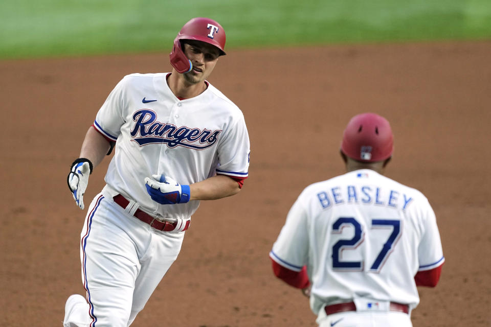 Texas Rangers' Corey Seager, left celebrates with third base coach Tony Beasley (27) as he jogs home after hitting a solo home run in the first inning of a baseball game against the Kansas City Royals, April 10, 2023, in Arlington, Texas. (AP Photo/Tony Gutierrez)