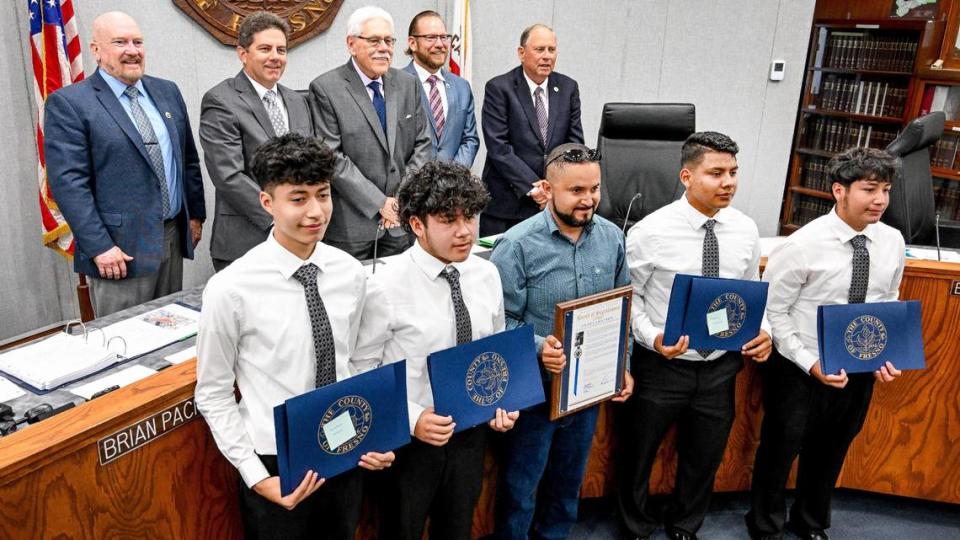 Members of the Mendota Junior High School Mathematics, Engineering, Science Achievement team (MESA) are photographed with their teacher and advisor, Carlos Tamayo, and members of the Fresno County Board of Supervisor’s during their meeting on Tuesday, Aug. 8, 2023 while accepting a proclamation acknowledging the team for placing first overall in the 2023 MESA USA National Engineering Design Competition in New Mexico in June. The team created an app called “FentaKNOW,” which connects their community with resources to combat the fentanyl crisis. In front from left is Jonathan Alfaro, Gerardo Portillo, teacher Carlos Tamayo, Anthony Trinidad, and Jimmy Fuentes.