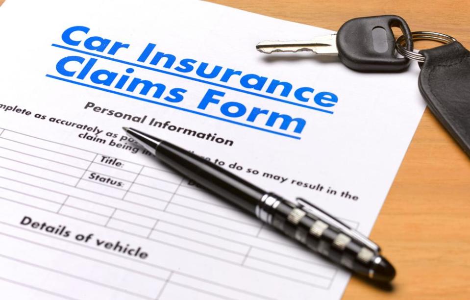 A car insurance claim form, a pen and a car key
