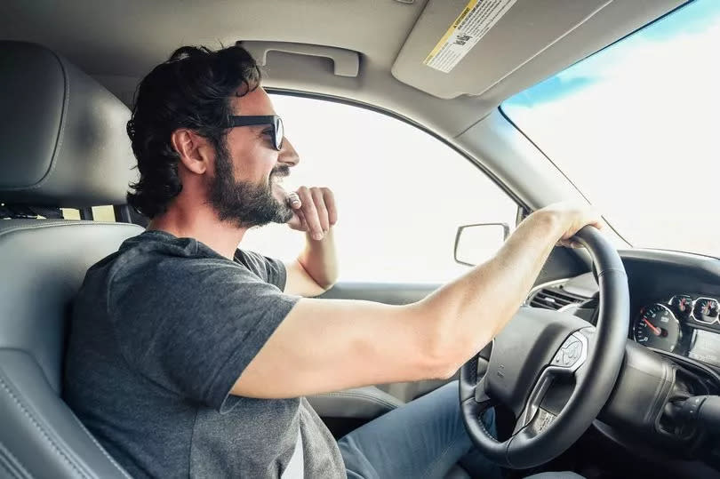 Man driving car in sunglasses