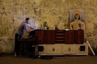 A member of the "Assemblea Cavallerizza 14:45" movement plays music on his computer at the Cavallerizza Reale building, which is occupied by the movement in Turin, Italy, July 16, 2016. REUTERS/Marco Bello