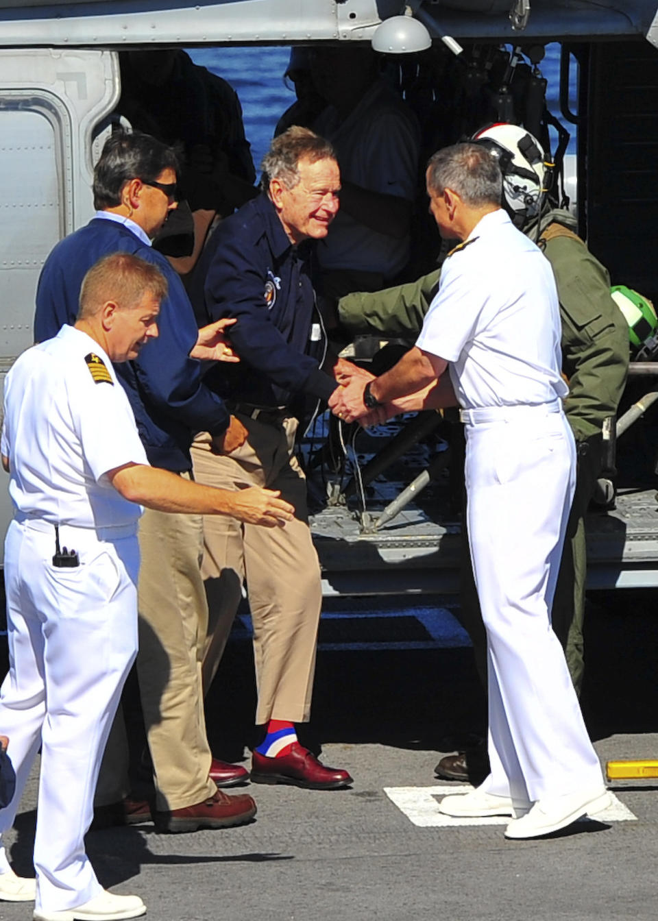 In this June 10, 2012 photo provided by the U.S. Navy, former President George H.W. Bush is greeted as he arrives aboard the aircraft carrier USS George H.W. Bush (CVN 77). Bush, his wife, Barbara, their son, former President George W. Bush, and other family members toured the carrier just off the coast of Maine, where the family has a home. George H.W. Bush is the newest aircraft carrier in the fleet. (AP Photo/U.S. Navy, Petty Officer 3rd Class Carrel Regis)