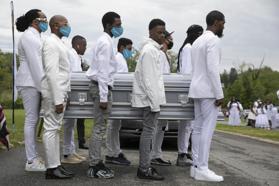 Family including Iran "Bang" Paylor, of Washington, far left, carry the casket of Paylor's mother, Joanne Paylor, 62, of southwest Washington, to a horse drawn hearse during her funeral at Cedar Hill Cemetery in Suitland-Silver Hill, Md., Sunday, May 3, 2020. Despite not having died from coronavirus, almost every aspect of her funeral has been impacted by the pandemic. (AP Photo/Jacquelyn Martin)