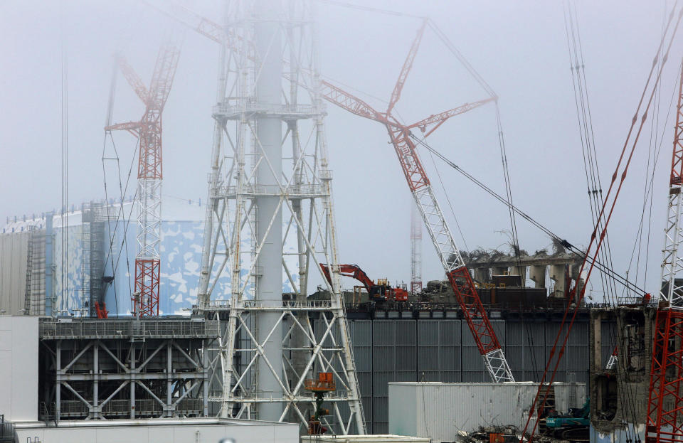 In this June 14, 2013 photo, remote-controlled and unmanned heavy equipments work on the No. 3 reactor building at the Fukushima Dai-ichi nuclear power plant in Okuma town, Fukushima prefecture, northeastern Japan. Eyeing dozens of aging reactors at home and hundreds of others worldwide that eventually need to be retired, Japanese industry sees a profitable market for decommissioning expertise. (AP Photo/Kyodo News) JAPAN OUT, MANDATORY CREDIT