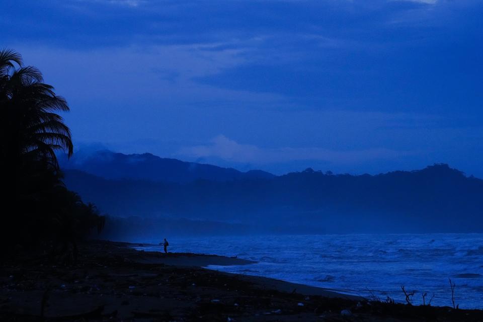 A volunteer of The Leatherback Project for the conservation of leatherback turtles searches for them on a beach near Armila, Panama, early Sunday, May 21, 2023. Sea turtles in Panama now have the legal right to live in an environment free of pollution and other detrimental impacts caused by humans, a change that represents a different way of thinking about how to protect wildlife. (AP Photo/Arnulfo Franco)