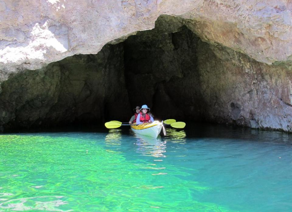 This April 14, 2013 photo shows kayakers at the Emerald Cave on the Arizona side of the Colorado River. The cave is one of the highlights of a trip on the river that begins with a guide company picking you up at a hotel on the Las Vegas Strip first thing in the morning, putting in near the Hoover Dam in a federal security zone that requires escort by an authorized livery service, and paddling through the Black Canyon. (AP Photo/Karen Schwartz)