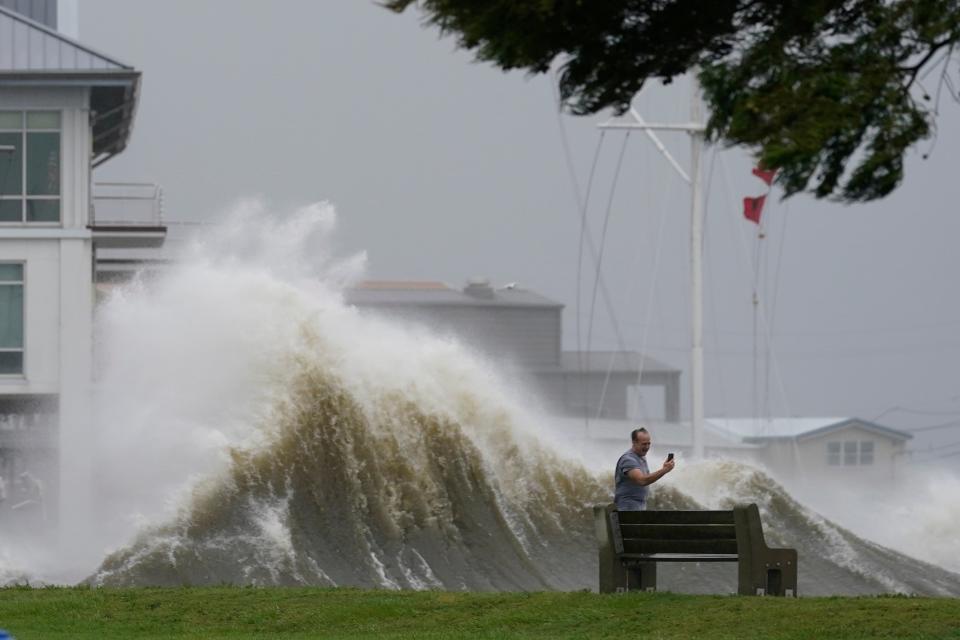 A man takes pictures of high waves along the shore of Lake Pontchartrain as Hurricane Ida nears, Sunday, Aug. 29, 2021, in New Orleans. (AP Photo/Gerald Herbert) (Copyright 2021 The Associated Press. All rights reserved.)