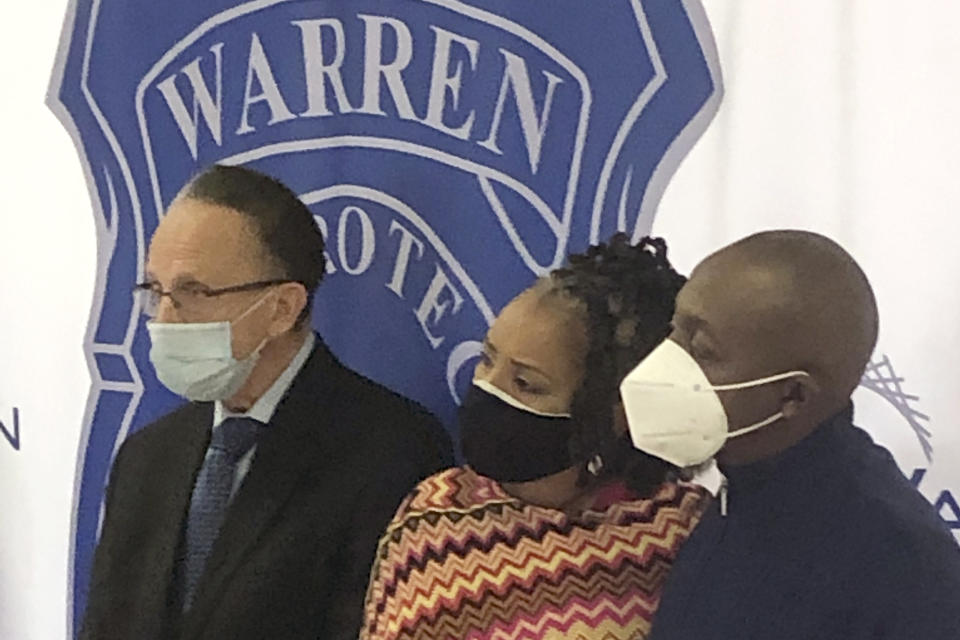 Warren, Mich., Mayor James Fouts, left, stands with Candace and Eddie Hall during a news conference, Wednesday, Sept. 30, 2020, at police headquarters in Warren. A 24-year-old white man has been charged with ethnic intimidation and other counts for firing shots into the Hall's home just north of Detroit after the family put a Black Lives Matter sign in their front window. (AP Photo/Corey Williams)