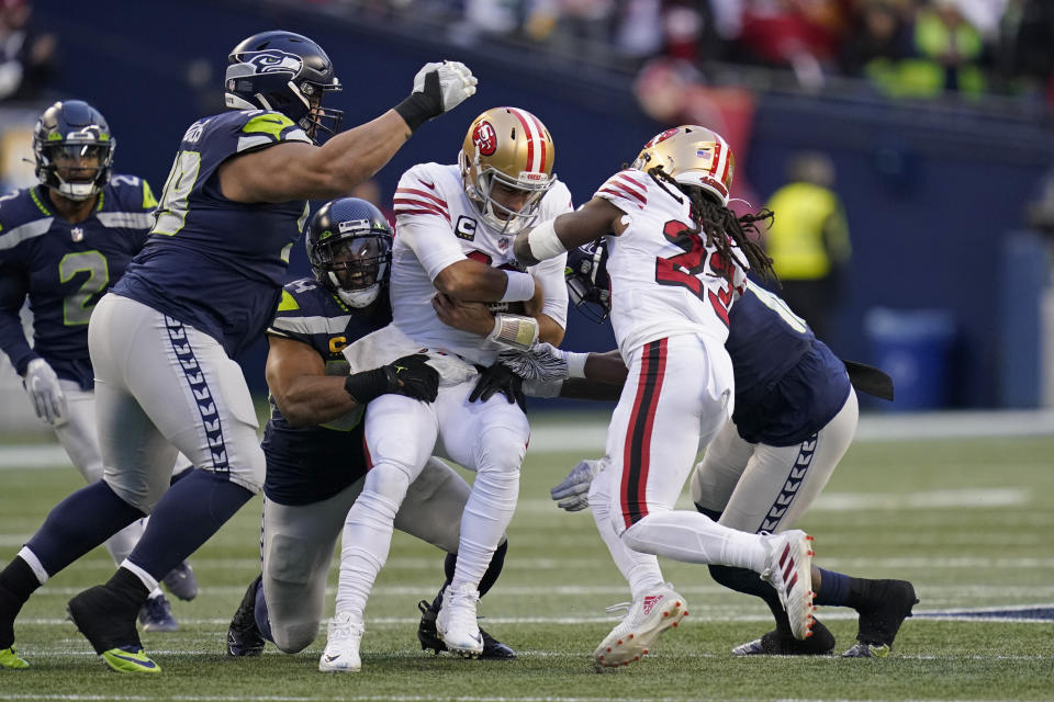 San Francisco 49ers quarterback Jimmy Garoppolo, center, is sacked by Seattle Seahawks middle linebacker Bobby Wagner, third from left, during the second half of an NFL football game, Sunday, Dec. 5, 2021, in Seattle. (AP Photo/Elaine Thompson)