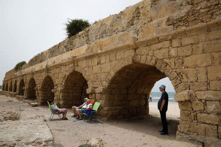 Beachgoers are seen on the beach near the aqueduct in the Old City of Caesarea, Israel, April 26, 2017 REUTERS/Amir Cohen