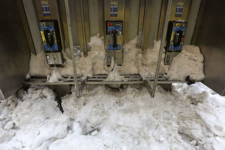 A phone booth is pictured covered in snow in Times Square in the Manhattan borough of New York, January 25, 2016. REUTERS/Carlo Allegri