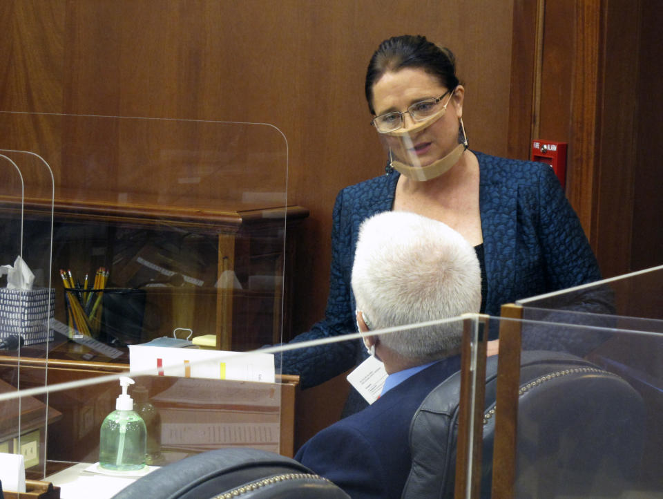 Alaska state Sen. Lora Reinbold speaks to Sen. Roger Holland before the start of the Senate floor session on Monday, April 26, 2021, in Juneau, Alaska. Reinbold said she traveled to Juneau by vehicle and ferry when Alaska Airlines said she was not permitted to fly on the carrier for what the airline said was her "continued refusal to comply with employee instruction regarding the current mask policy." It was not clear how long the suspension would be in place. (AP Photo/Becky Bohrer,Pool)