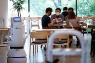 Customers wait at a cafe where a robot that takes orders, makes coffee and brings the drinks straight to customers is being used in Daejeon