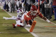 Kansas City Chiefs quarterback Patrick Mahomes (15) scores on an 8-yard touchdown run ahead of Buffalo Bills safety Micah Hyde (23) during the first half of an NFL divisional round playoff football game, Sunday, Jan. 23, 2022, in Kansas City, Mo. (AP Photo/Charlie Riedel)