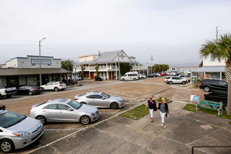 Two women walk through downtown Apalachicola, Florida