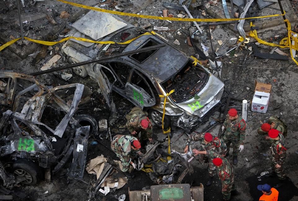 Lebanese Army investigators inspect the site of a car bomb explosion, in a Shiite area and stronghold of the Lebanese militant group Hezbollah, in the southern suburb of Beirut, Lebanon, Friday, Jan. 3, 2014. An explosion tore through a crowded commercial street Thursday in a south Beirut neighborhood that is bastion of support for the Shiite group Hezbollah, killing several people, setting cars ablaze and sending a column of black smoke above the Beirut skyline. (AP Photo/Hussein Malla)