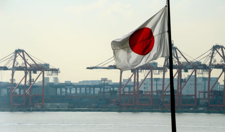 Japan's national flag flies in front of the container pier of Tokyo port, on January 24, 2013. Japan's current account surplus last year shrank to its lowest in almost three decades, data showed on Friday, as exports to China and Europe slumped in a worrying sign for the world's third-largest economy